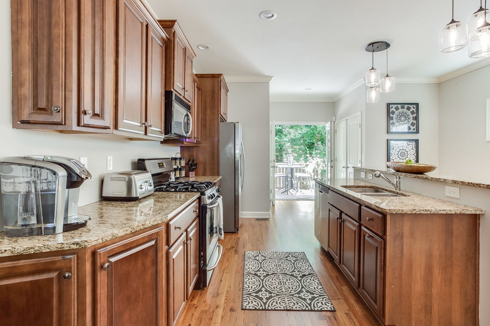 The Kitchen with Breakfast Bar, Refrigerator, Coffee Maker, Toaster, and Microwave.