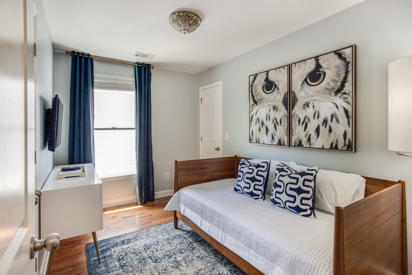 Bedroom with a Single Bed, Dresser, TV, and Lamp.