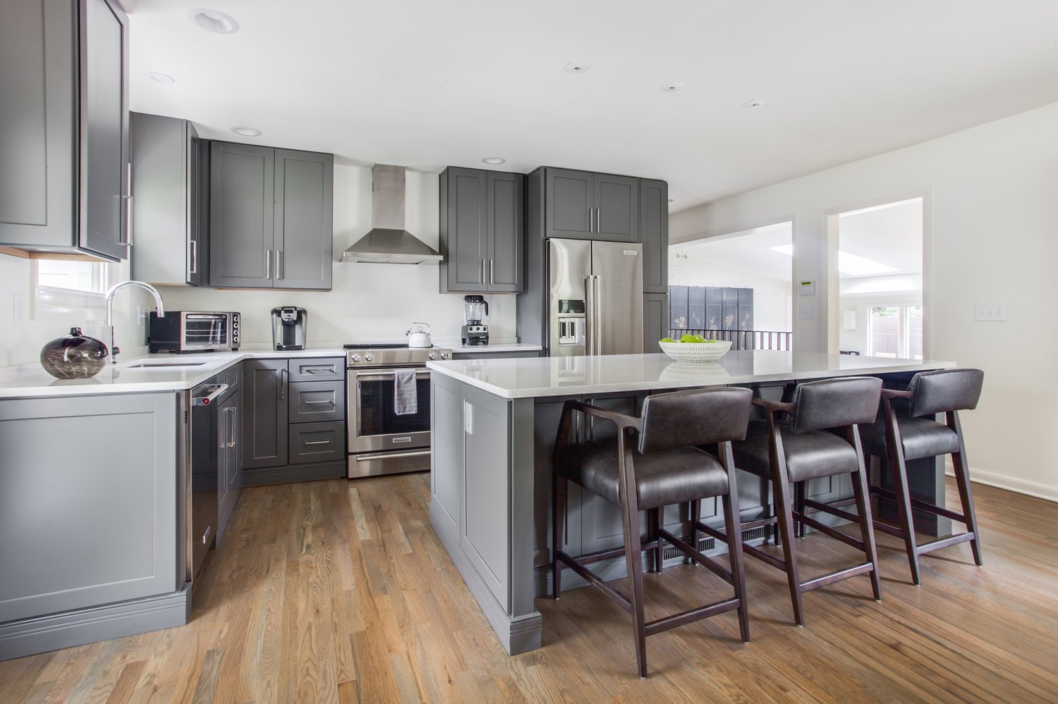 Kitchen with Breakfast Bar, Stools, Coffee Maker, and Refrigerator.
