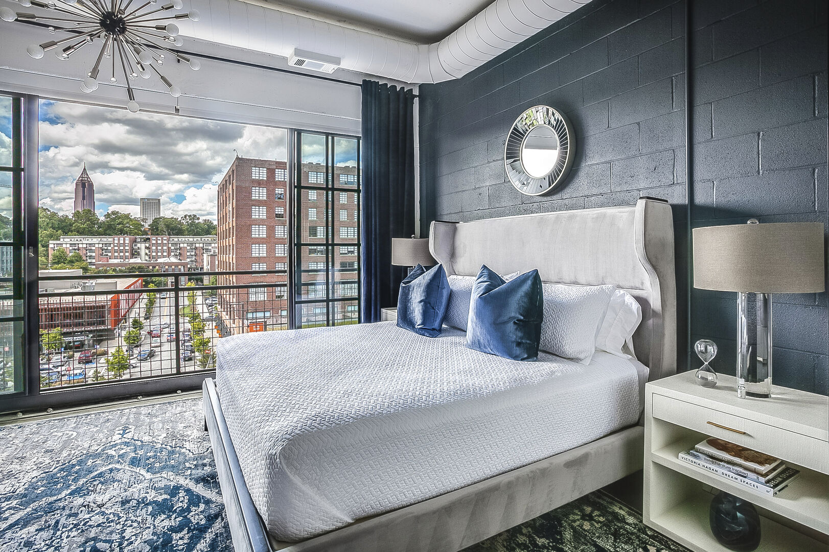 Sleeping area with a large bed, two nightstands, and an open window overlooking the city. Sleeping area with a large bed, two nightstands, and an open window overlooking the city.