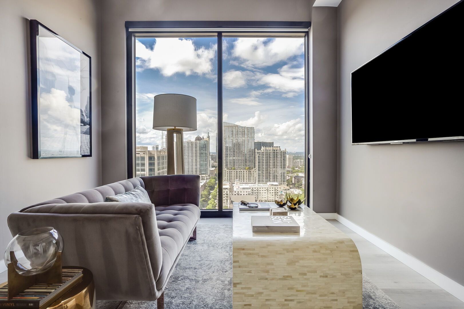Living Area with Sofa, TV, and Large Window with City View