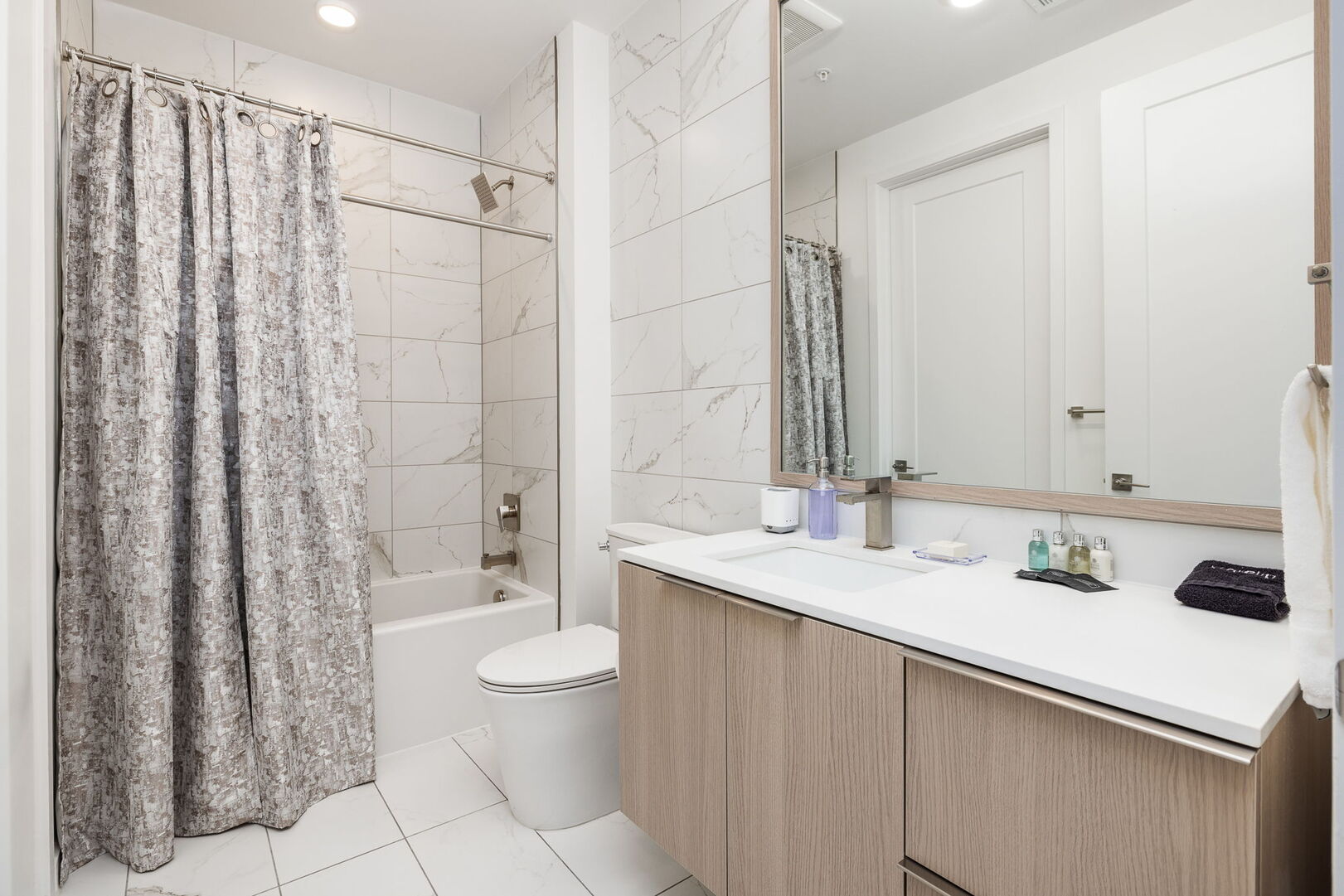 An en-suite bathroom featuring a single vanity and a spacious tub and shower. An en-suite bathroom featuring a single vanity and a spacious tub and shower.