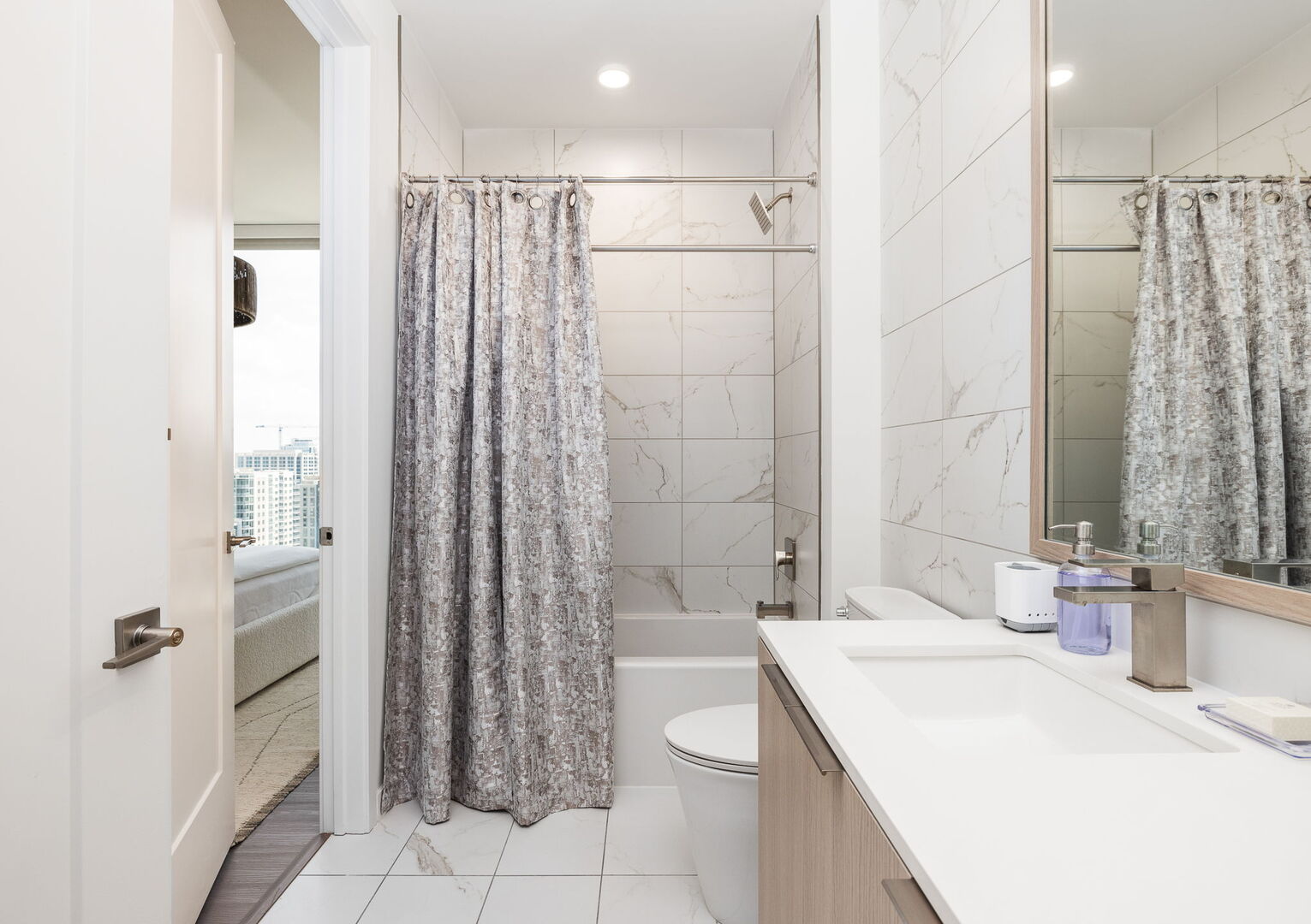 An en-suite bathroom featuring a single vanity and a spacious tub and shower. An en-suite bathroom featuring a single vanity and a spacious tub and shower.