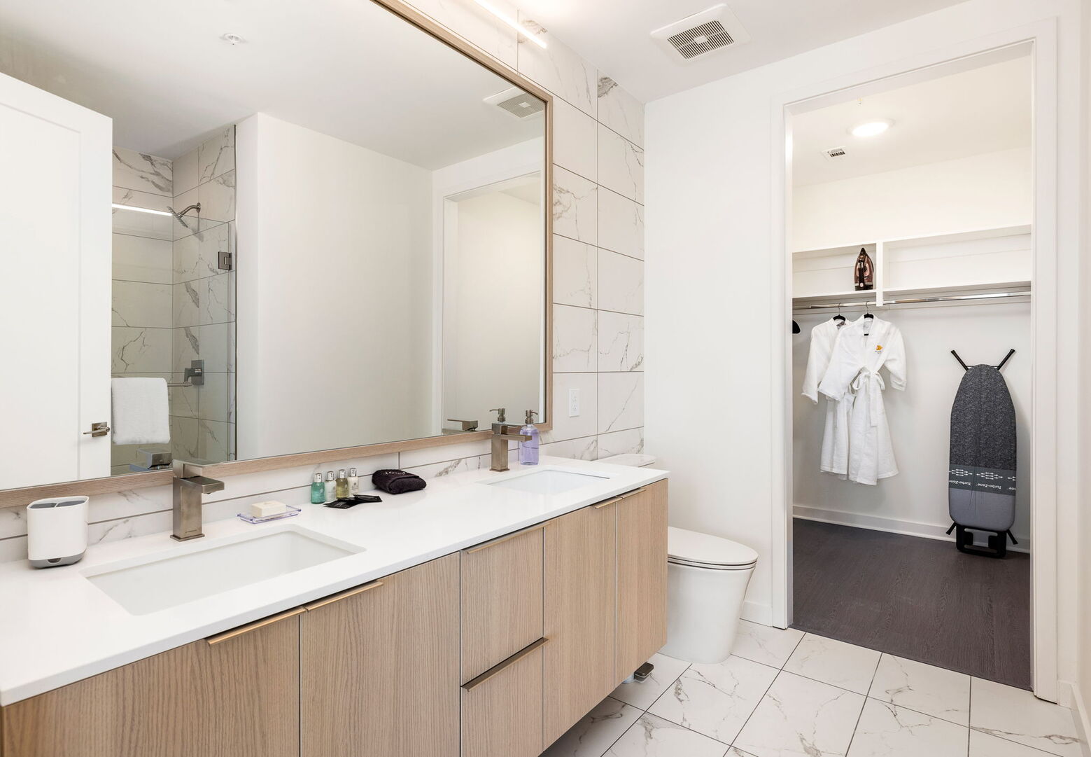 An en-suite bathroom featuring a double vanity and a spacious walk-in shower and closet An en-suite bathroom featuring a double vanity and a spacious walk-in shower and closet