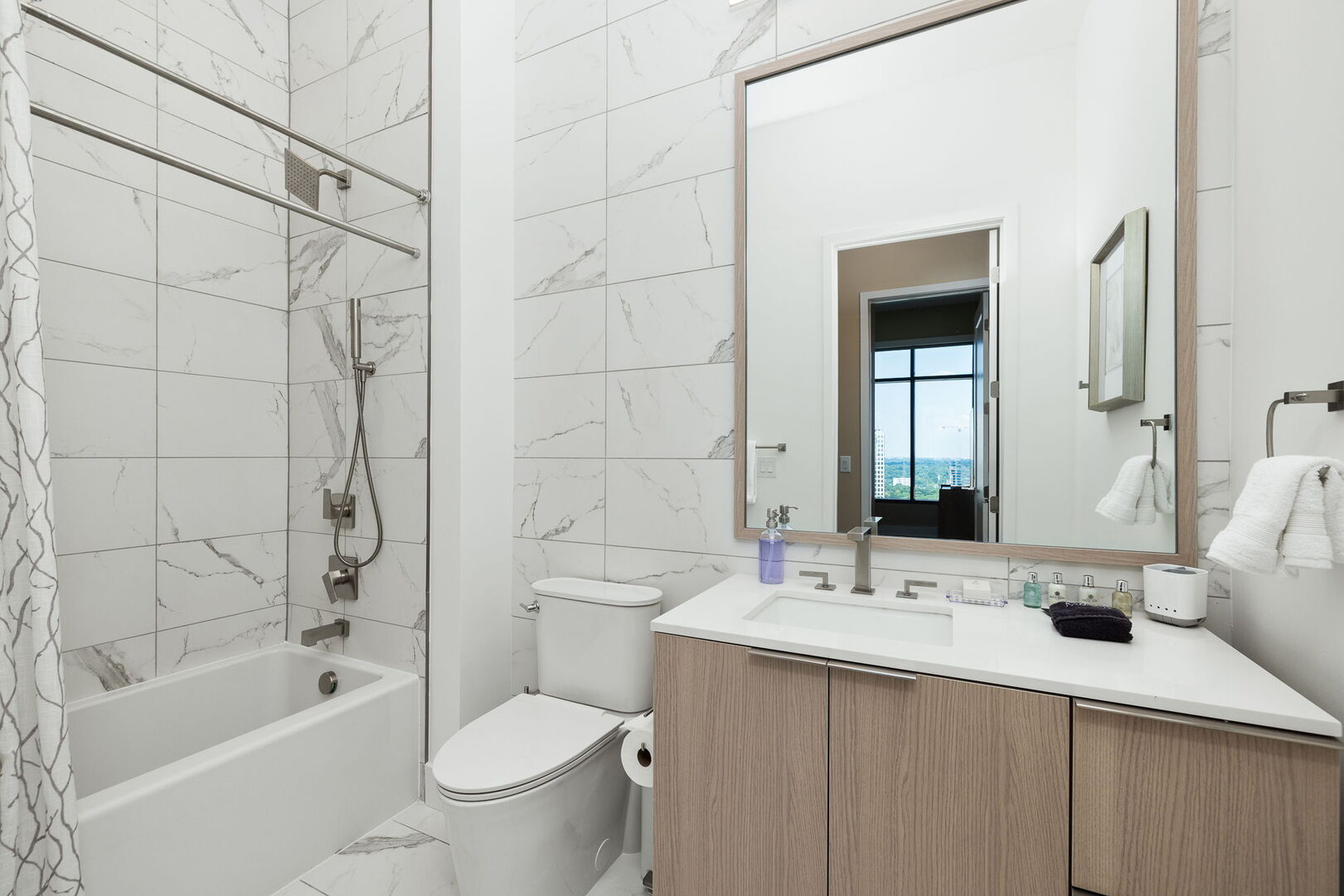 An en-suite bathroom featuring a single vanity and a spacious tub and shower. An en-suite bathroom featuring a single vanity and a spacious tub and shower.