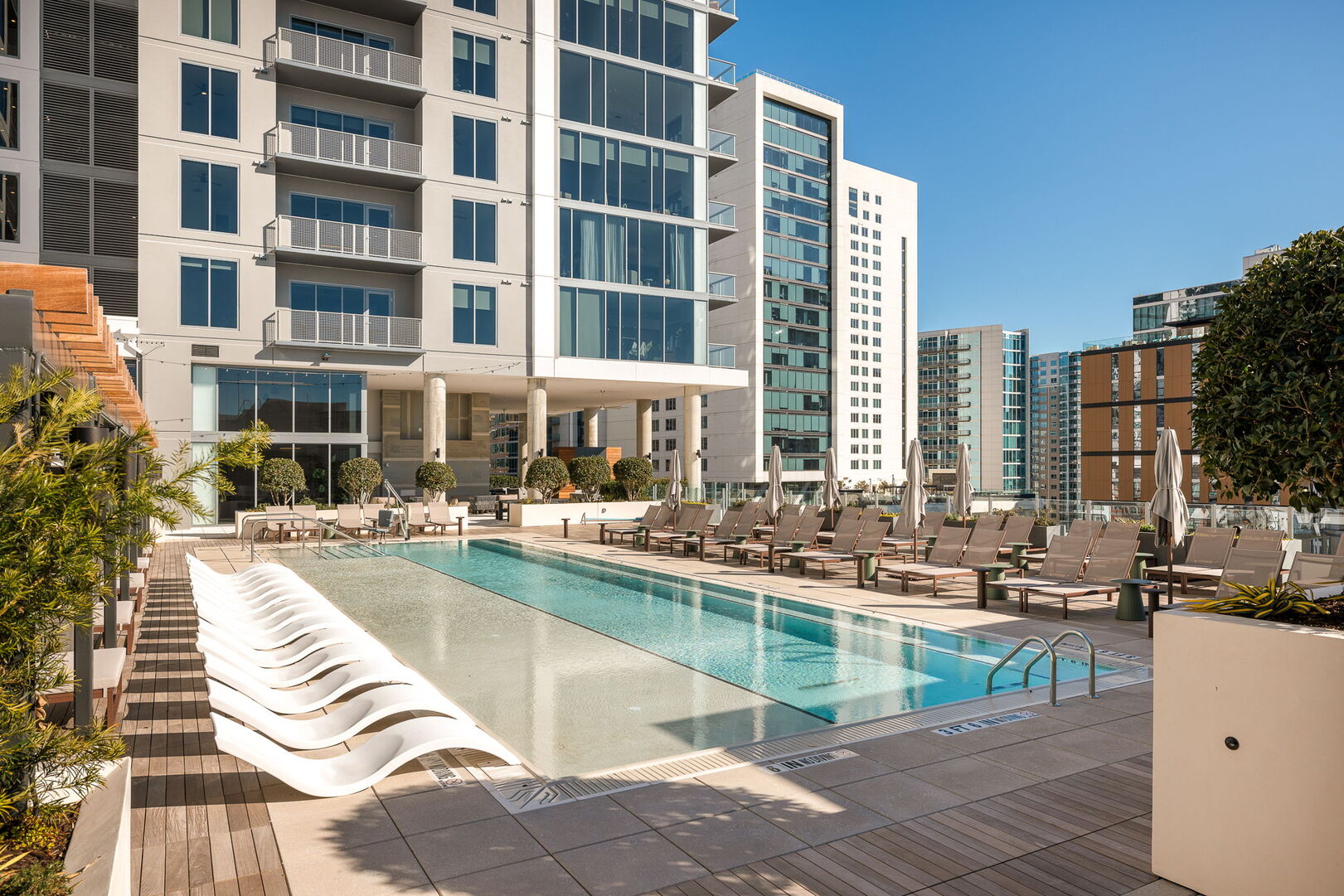 Luxury pool deck featuring private cabanas and pool loungers Luxury pool deck featuring private cabanas and pool loungers