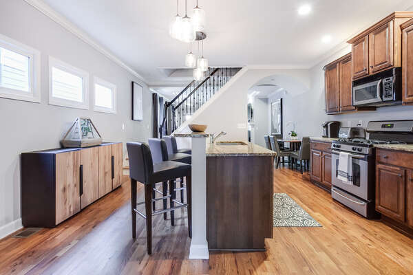Breakfast Bar with Stools, Buffet Console, Staircase, Dining Set, and the Kitchen.