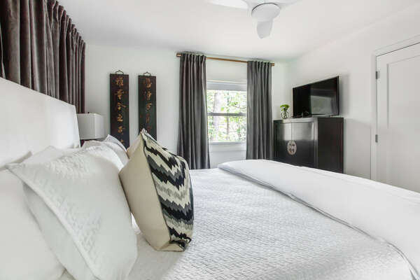 Bedroom with Large Bed, TV, and Dresser.