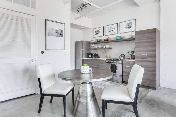 Dining area of this Apartment Near Ponce City Market, with the kitchen in the background.