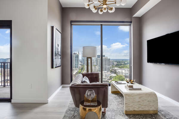 Living Area with Sofa, TV, and Large Window with City View