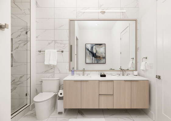 An en-suite bathroom featuring a double vanity and a spacious walk-in shower and a tub