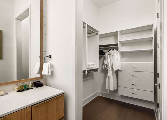 An en-suite bathroom featuring a double vanity and a spacious walk-in shower and closet